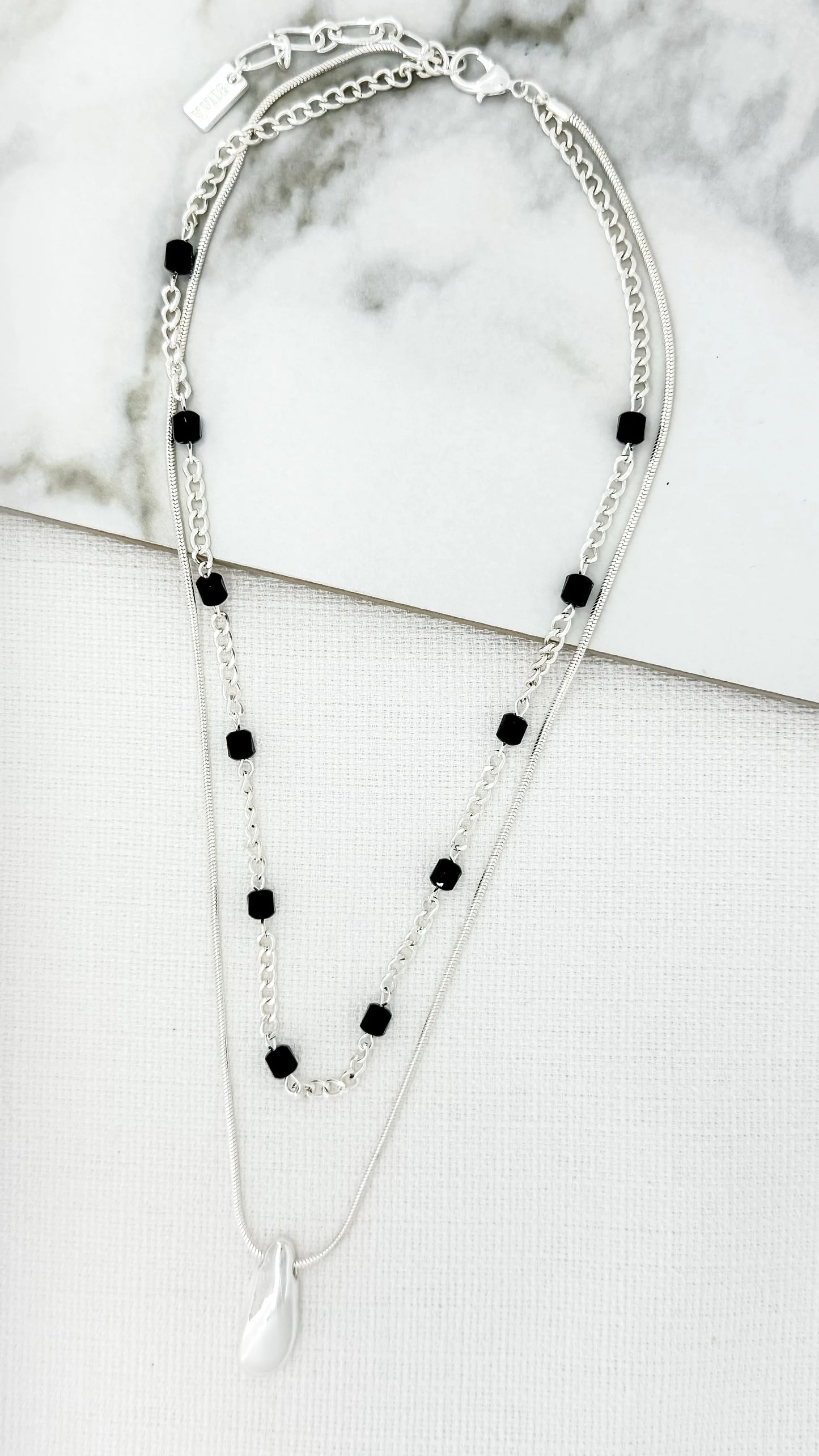 Short silver double layer necklace with grey crystals and a chunky pebble pendant